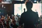 Fototapeta Zwierzęta - Back view of a male speaker addressing a diverse crowd at a business event in a well-lit conference room.