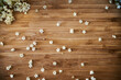Top view of little white elderflowers on a wooden background. Aerial view of white little elder or elderberry flowers on a table show that spring time is coming and elderflower cordial can be made