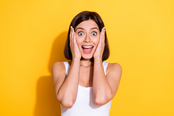 Poster - Photo portrait of attractive young girl touch cheeks shocked wear trendy white outfit isolated on yellow color background