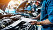 An auto mechanic with a clipboard checking a car in an auto repair shop