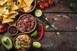Food Red Background. Vegetarian Mexican Bowl with Refried Black Beans, Guacamole, Salsa, Chili, and Tortilla Chips on Vintage Wooden Background