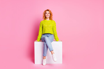 Poster - Photo of lovely gorgeous cute cheerful woman dressed stylish clothes sitting cube isolated on pink color background