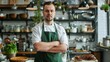 © Julia Jones - Portrait of a confident young male chef in a green apron standing in a professional kitchen