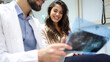 © PeopleVideos - Beautiful woman watching her x-ray together with her dentist