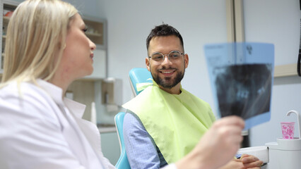 Wall Mural - Dentist and patient making a treatment plan together