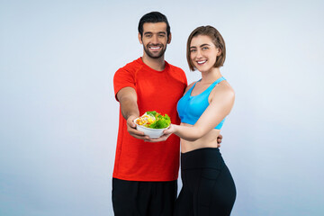 Wall Mural - Full body length gaiety shot athletic and sporty young couple with healthy vegan food in standing posture on isolated background. Healthy active and body care by vegetarian lifestyle.