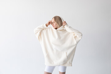 Sticker - Beautiful blonde woman posing in white hoodie and leggings posing against white background