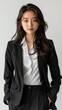 © ArtistryAlchemy - Young Asian business woman in black suit isolated on white background.