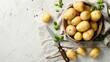 Bowl with raw potatoes and knife on light background.