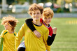 © LIGHTFIELD STUDIOS - A group of young men standing confidently on top of a soccer field, proudly celebrating their victory. The bright green grass under their feet symbolizes their triumph and unity.