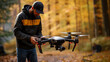 Hiker hoodie man launching drone photo realistic image. Recreational UAV operator photography wallpaper. Autumn forest backdrop picture scene. Technology concept photorealistic