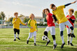 © LIGHTFIELD STUDIOS - A group of young boys joyfully kicking around a soccer ball, showing off their skills and building camaraderie as they play together in a friendly match.