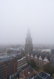 Fototapeta Las - The Martinitoren on a foggy morning in the historical city centre of Groningen.