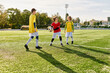 © LIGHTFIELD STUDIOS - A dynamic group of young people stands triumphantly atop a vibrant soccer field, celebrating their victory. The sun sets in the background as they showcase their teamwork and passion for the sport.