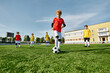 © LIGHTFIELD STUDIOS - A dynamic scene unfolds as a group of young boys energetically kick around a soccer ball, showcasing their skills and teamwork on the field.