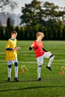 © LIGHTFIELD STUDIOS - Two energetic young boys are joyfully kicking a soccer ball around, showcasing their skills and passion for the sport.