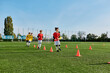 © LIGHTFIELD STUDIOS - A group of young men stands proudly on the top of a soccer field, smiling and high-fiving each other after a successful game. The grassy field stretches beneath them as they celebrate their victory.