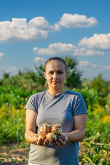 Poster - a woman holds an onion in her hands close-up.