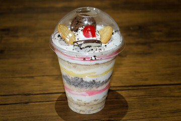 Wall Mural - Close-up shot of a mixed biscuit dessert with yogurt and cherry on a glass cup