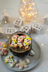 Wall Mural - Cup of coffee with marshmallows. Marshmallow snowman in a Santa Claus hat. Winter drink. Christmas sweet food. Top view.