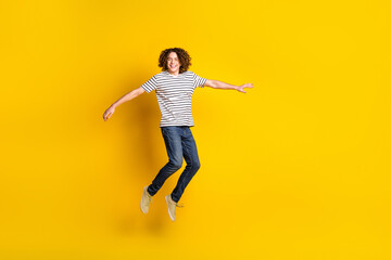 Canvas Print - Full size portrait of nice young man jump empty space wear striped t-shirt isolated on yellow color background