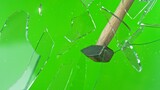 Fototapeta Dmuchawce - Freeze motion of glass-breaking hammer, shattering against green background