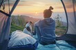 Young woman sitting in a tent with a sleeping bag and dog watching the view of a valley at sunset. Vibrant color photography. Wide angle lens. Beautiful The photo was taken from behind the girl's head
