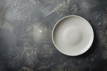 A high-angle view of a white bowl placed on top of a black table, emphasizing the contrast between the two colors and textures