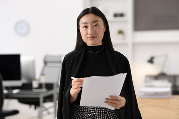 Canvas Print - Portrait of beautiful businesswoman with documents in office