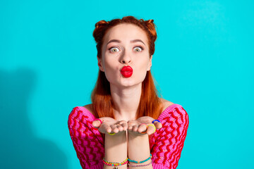 Wall Mural - Photo of excited funky lady dressed pink knitted shirt sending you arms kiss isolated blue color background