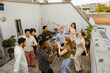 © Maskot - Group of carefree male and female friends dancing while celebrating during dinner party in balcony