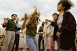 © Maskot - Carefree woman dancing with multiracial friends at party on rooftop deck