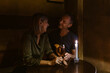 © Maskot - Happy mature couple enjoying candlelight date while having wine at restaurant