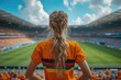 Girl fan stands in stadium. Concept of sport competitions, tournaments and sport games. Young football fan supporting her team at stadium.