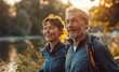 Handsome middle-aged smiling grey haired man walking with beautiful wife by city park with pond, enjoying sunny evening together. Sporty active people, healthy lifestyle concept training image.