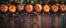   A Row Of Pumpkins Atop A Wooden Table, Adjacent To Flowers And Berries Adorning A Wooden Fence