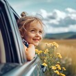 Smiling young girl looking out from car window on a sunny day