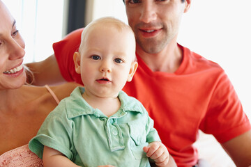 Poster - Parents, happy and hug baby in portrait at home for learning, development and bonding together. Mom, father and love child smile in living room for family, relationship or memories with each other