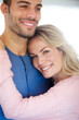 © peopleimages.com - Couple, happy and embrace in portrait for love, relationship or memories together. Man, woman and romantic hug smile for dating, compassion or care in home cheerful for support, commitment and trust