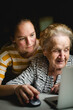 A girl teaches her grandmother how to use the computer.