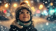A Child Wearing A Winter Hat And Scarf Looks Up At The Falling Snow. The Background Features Blurred Lights.