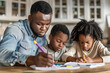 A man is writing on a piece of paper while two young girls are drawing. Concept of family bonding and creativity. The man's presence suggests that he is a father or a guardian