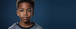 An African American Juvenile Boy, Isolated On A Sapphire Background With Copy Space