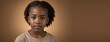 An African American Juvenile Girl, Isolated On A Amber Background With Copy Space