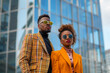 African-American luxury fashionable couple in the city, copy space of two stylish models in branded clothes and sunglasses with a skyscraper behind them