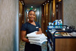 Happy black chambermaid working in  hotel and looking at camera.