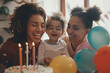 Happy lesbian couple celebrating birthday of their child. Gay mothers with their kid at home.