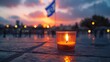 Yom HaZikaron theme, a single candle lit in a small glass, placed on a stone surface with the backdrop of a waving Israeli flag at half-mast