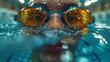 Underwater shot of a man swimming in a pool wearing goggles and cap