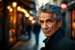 Handsome senior man with gray hair and blue eyes looking at the camera in a narrow street in Paris, France